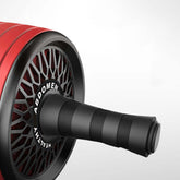Home fitness abs wheel close-up showcasing the ergonomic handle and wheel design in red color.