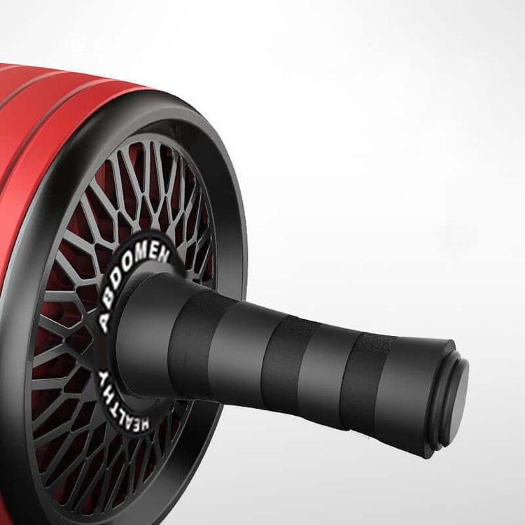 Home fitness abs wheel close-up showcasing the ergonomic handle and wheel design in red color.